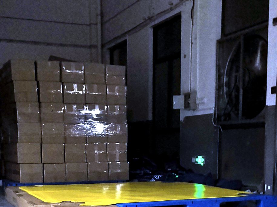 Yellow spill berm laid on pallets in the packing bay, with cartons stacked beside it